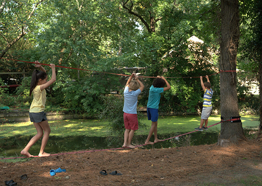 Children playing in a yard around a tree.