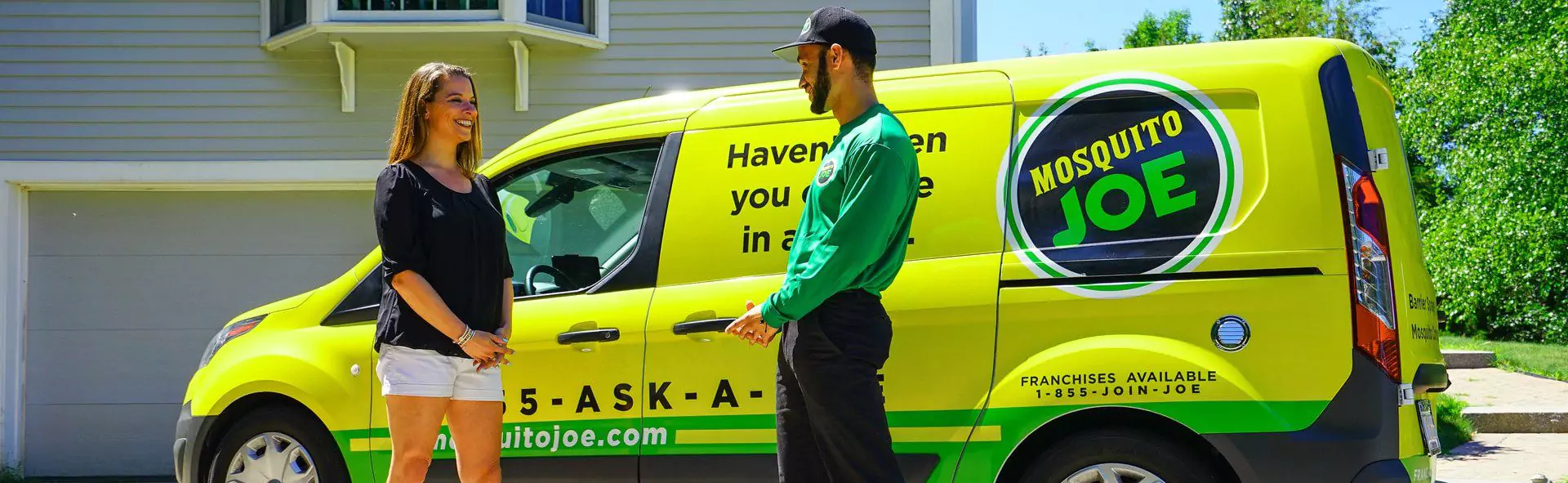 Mosquito Joe tech talking to a client in front of a Mosquito Joe van.