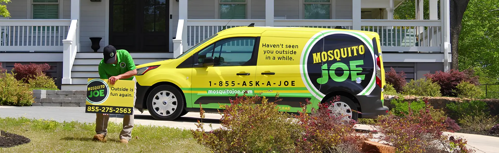 Mosquito Joe professional placing company sign on front yard with the company van