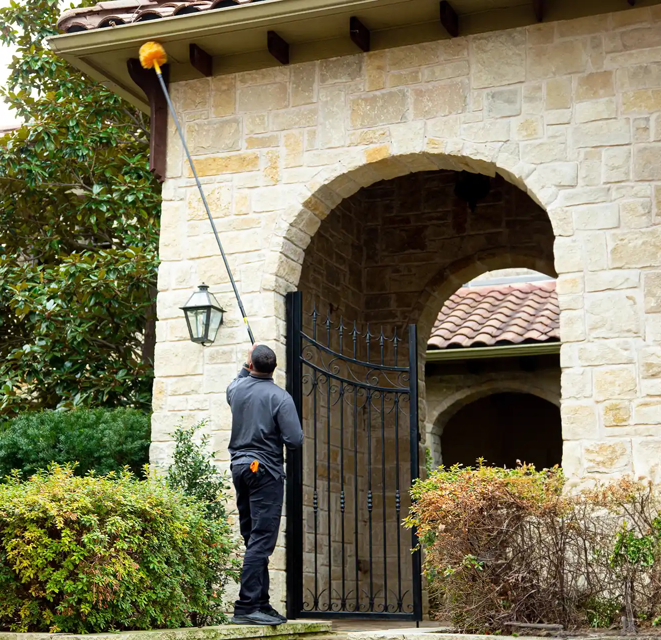 Mosquito Joe technician treating the roof of a customers home.