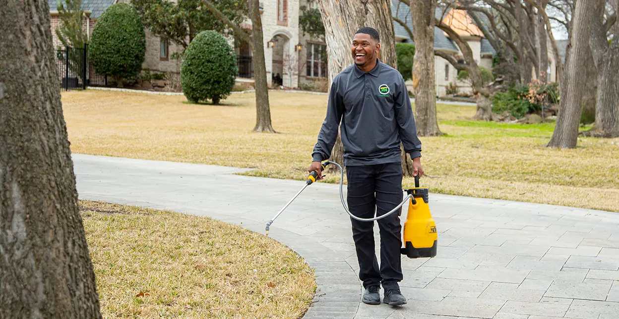 Mosquito Joe technician spraying the perimeter of a customers lawn.