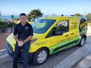 Mosquito Joe owner posing for photo on yellow service van.