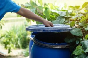 man opening trash can lid outside